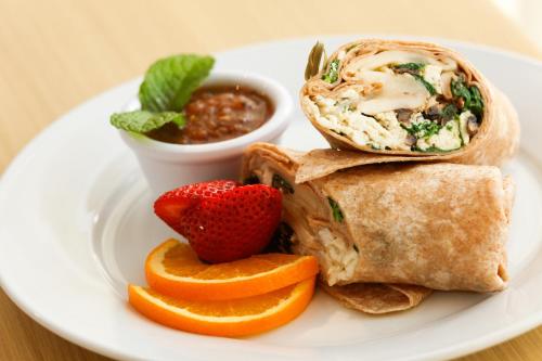 a plate of food with a wrap and fruit and salsa at Holiday Inn Dallas Market Ctr Love Field by IHG in Dallas