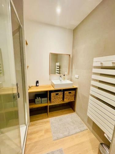 une salle de bain avec un lavabo et un miroir dans l'établissement VUE MER L'horizon Baulois, à La Baule