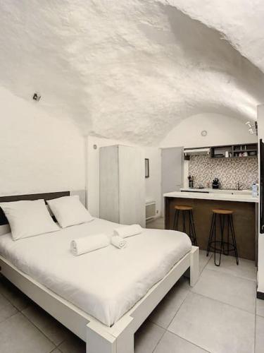 une chambre avec un grand lit et une cuisine dans l'établissement Le Panisse - Studio - 9 min Palais - Cannes, à Cannes