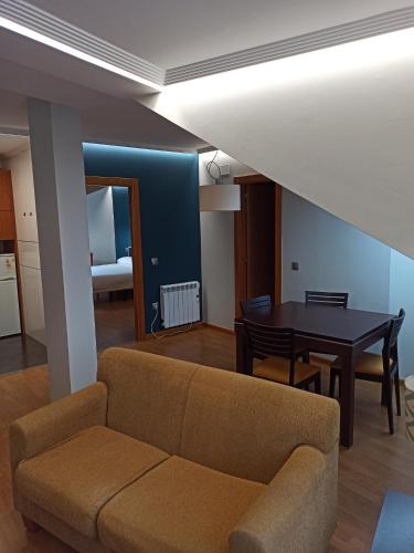 ein Wohnzimmer mit einem Sofa und einem Tisch in der Unterkunft Apartamentos ARVA París in León