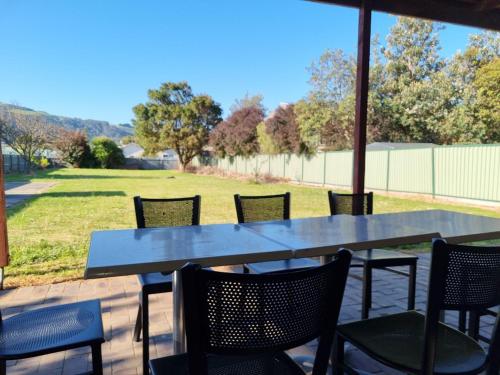 a table and chairs with a view of a field at Apollo Bay Holiday House on Nelson in Apollo Bay