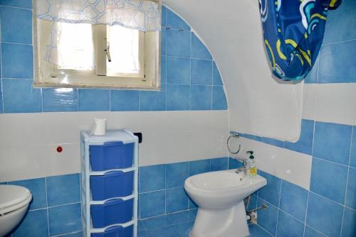 uma casa de banho em azulejos azuis com um WC e uma janela em LOVE NEST casa vacanze Ercolano em Ercolano
