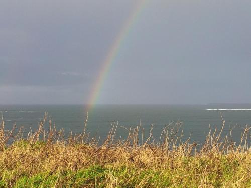 a rainbow in the sky over the ocean at Ocean Heights B&B in Lissadell