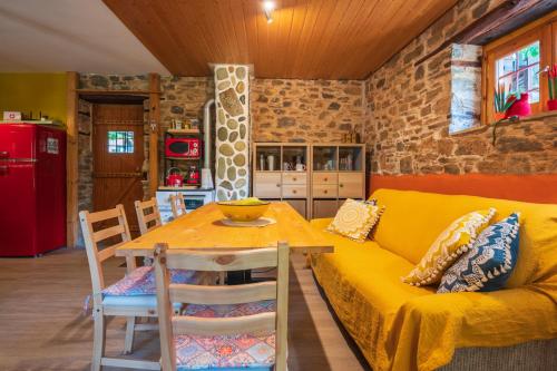 a living room with a yellow couch and a table at The Pirates Lodge Milina - Chill-out in Strandnähe in Milína