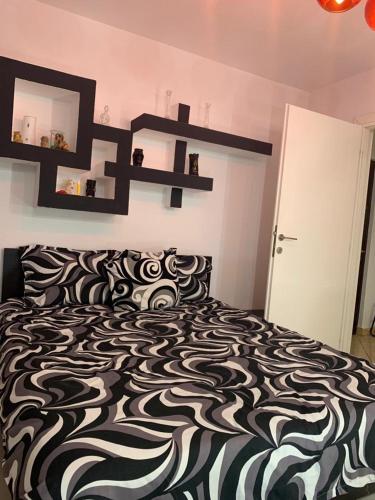 a bedroom with a bed with a black and white comforter at Apartament B Orizont in Bacău