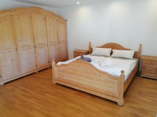 a bedroom with a wooden bed and two wooden cabinets at Ferienhaus am Kellpointhof in Miesbach