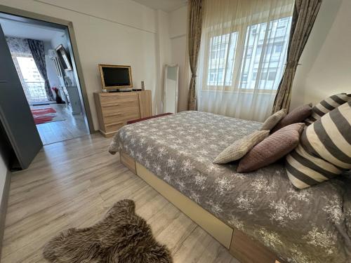 a bedroom with a bed with pillows and a television at Downtown "Rendez-Vous" Luxury in Bacău