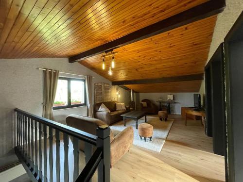 - un salon avec un plafond en bois et un canapé dans l'établissement jolie maison de campagne à 100 m de l'étang, à Rhodes
