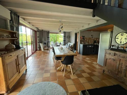 une cuisine avec une table et des chaises dans une pièce dans l'établissement jolie maison de campagne à 100 m de l'étang, à Rhodes