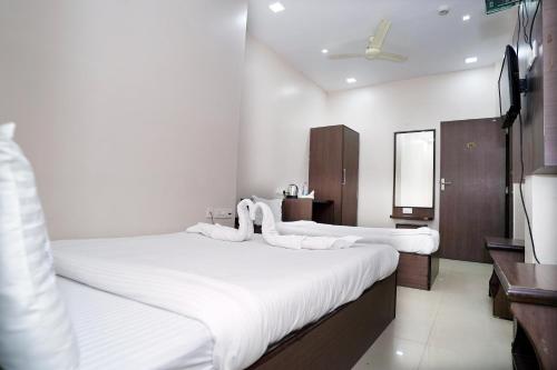 a bedroom with two beds and a mirror at Sonar Bangla Guest House in Kolkata