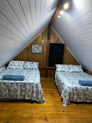 2 letti in una camera con mansarda di cabana canto da maré a Bombinhas