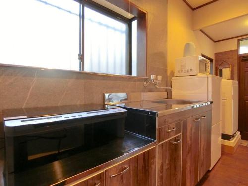 a kitchen with a black stove and a refrigerator at 【Hotel Futaba HeightsC】good access, up to 5 guests in Tokyo