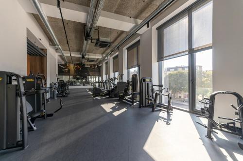 a gym with rows of tread machines and windows at Hotel Campus 90 - Free Parking in Varna City