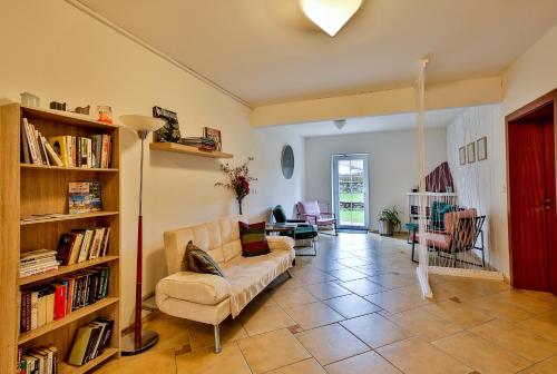 a living room with a couch and a book shelf at Hotel Barborka in Přední Výtoň