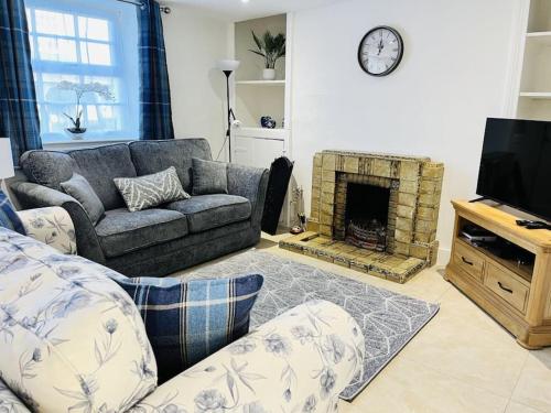 ein Wohnzimmer mit Couch und Kamin in der Unterkunft Lovely Cottage with Mountain Views in Gilwern