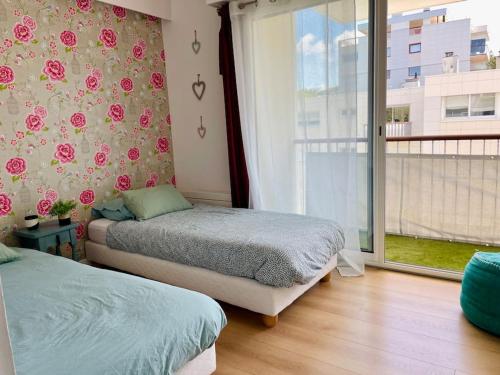 1 Schlafzimmer mit 2 Betten und einem Fenster in der Unterkunft Le Clos Boisé Résidence des Faunes in La Baule
