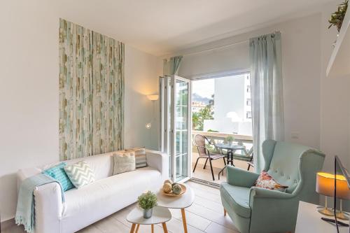 Andaluz Apartments Toboso في نيرخا: غرفة معيشة مع أريكة وكراسي وشرفة