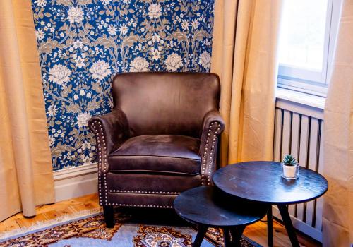 a brown chair and a table in a room at Park Hotel Linköping Fawlty Towers in Linköping