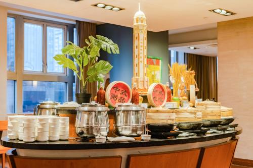 um buffet com panelas e frigideiras sobre uma mesa em Dekin Hotel Chongqing Jiefangbei em Chongqing