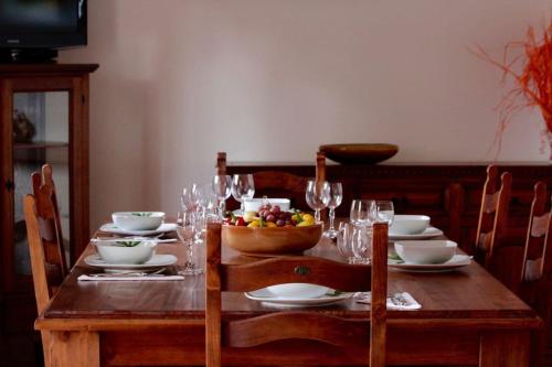 a wooden table with a bowl of fruit and wine glasses at Tra Mare e Pineta in Viareggio