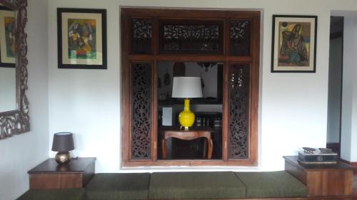 a room with a window with a lamp on a table at Kaya Residence Kandy in Kandy