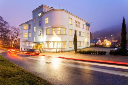 a large white building on a city street at night at Hotel Grand in Tanvald