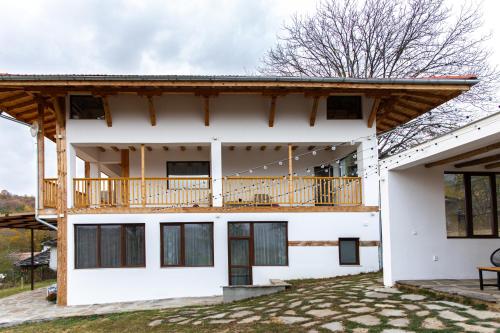 ein Haus mit Balkon darüber in der Unterkunft Villa Oreh Kravenik - Вила Орех Кръвеник in Kravenik