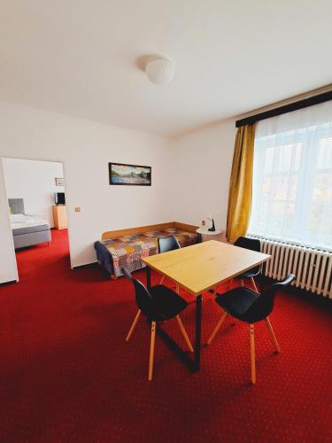 a room with a table and two chairs and a bed at Hotel Grand in Tanvald