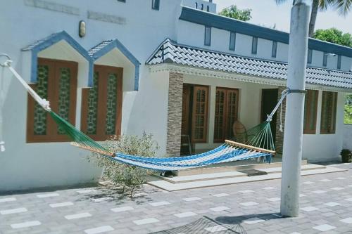 a hammock in front of a house at Varkala- Aroma Ac pvt Villa hammocks kitchen in Varkala
