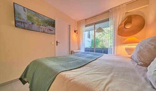 une chambre avec un grand lit avec une fenêtre dans l'établissement Sunset-Apartment St-Tropez-swimming pool-parking, à Saint-Tropez