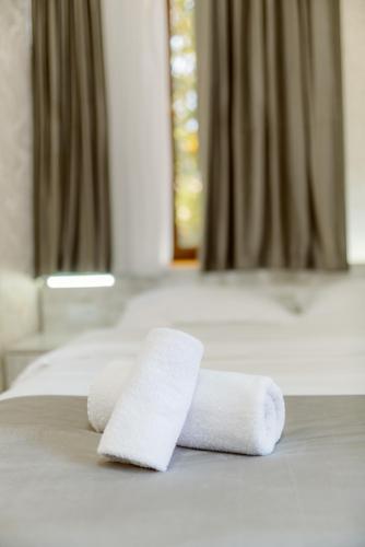 two rolled towels sitting on top of a bed at Opera Avenue Hotel in Yerevan