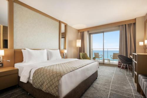 a hotel room with a bed and a large window at Ramada Resort by Wyndham Unye in Unye