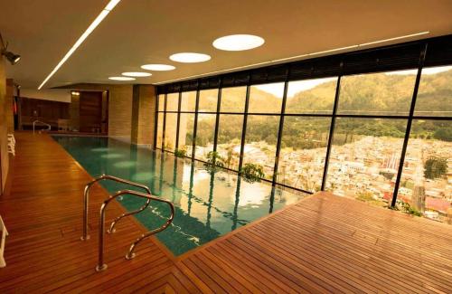 a swimming pool in a building with a large window at Loft estilo Japonés in Bogotá