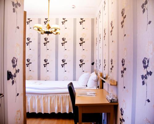 a bedroom with a bed with flowers on the walls at Park Hotel Linköping Fawlty Towers in Linköping