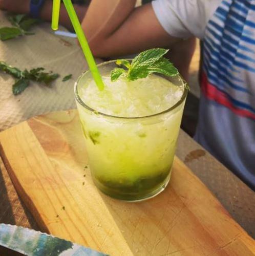 a drink on a wooden cutting board with a green drink at Ecològic Vinyols Camp in Vinyols i els Arcs