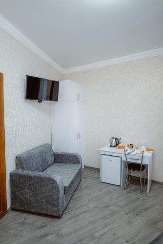 a room with a couch and a table and a desk at Opera Avenue Hotel in Yerevan