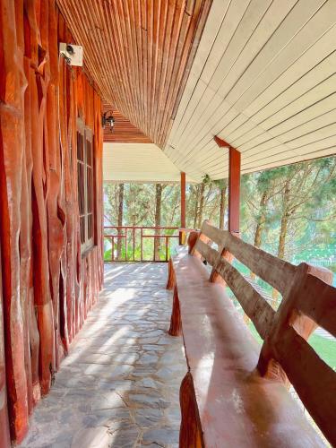a wooden bench sitting on the side of a building at เนริสารีสอร์ท เขาค้อ in Ban Khao Ya Nua