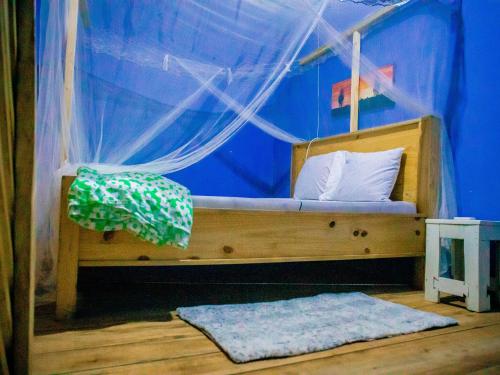 a bed in a room with a blue wall at Arusha Jua Eco Home- on coffee farm in Arusha