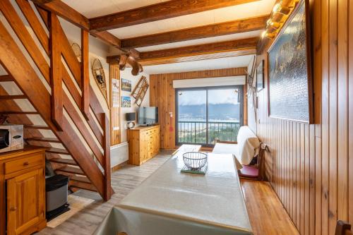 salon z drewnianymi ścianami i dużym oknem w obiekcie Lac et Montagne - Vue sur le lac de Matemale w mieście Les Angles
