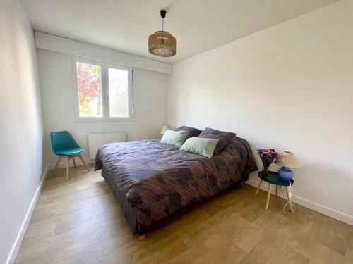 une chambre avec un lit et une chaise dedans dans l'établissement Vue Port de plaisance : Le Voilier, à La Baule