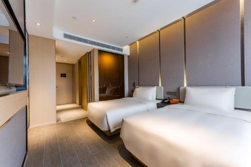 a hotel room with two beds and a kitchen at Atour Hotel Shengzhou in Shengzhou
