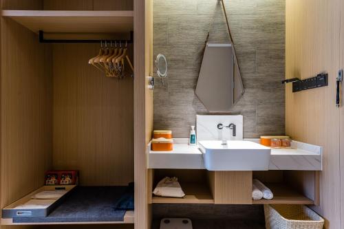 a bathroom with a white sink and a mirror at Atour Hotel Shengzhou in Shengzhou