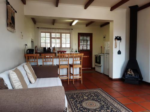 a living room with a couch and a kitchen at Rhodene Farm Cottages in Prince Alfreds Hamlet