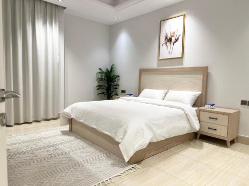 a bedroom with a large bed and a window at Luxurious 3 Bedroom Apartment - 5 minutes to Boulevard in Riyadh