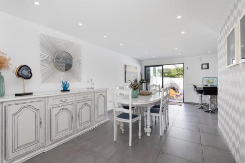 a white kitchen with a table and a dining room at Centralgarve - Villa Crown 22 in Quarteira