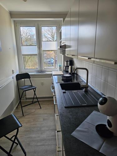a kitchen with a counter and two chairs in it at Apartment mea in Berlin