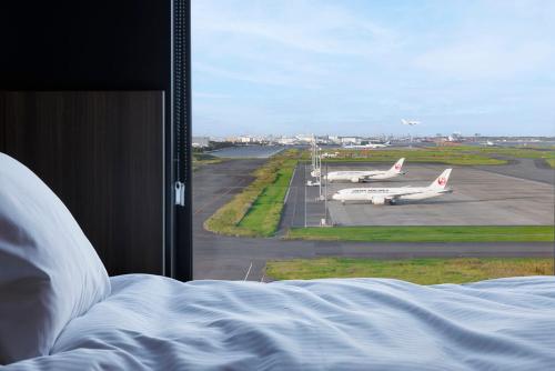 een uitzicht vanuit een raam op een landingsbaan van de luchthaven met vliegtuigen bij Hotel Metropolitan Tokyo Haneda - 2023-10-17 Grand Opening in Tokyo