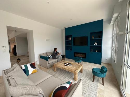 a person sitting on a couch in a living room at Le Petit Versailles Loire Tours in Rochecorbon