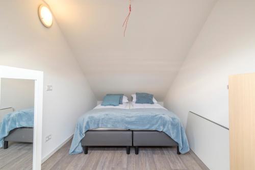 a bedroom with a bed with a blue blanket at Hollandse Nieuwe in Katwijk aan Zee