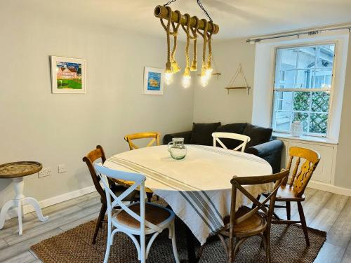 comedor con mesa y sillas en Honeysuckle cottage, a cosy coastal retreat, en Dornoch